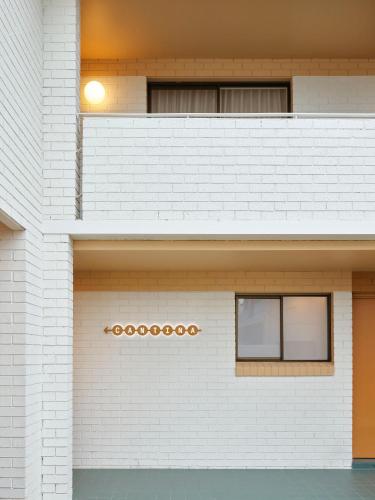 a white brick wall with two windows on it at The Isla & Casita in Batemans Bay