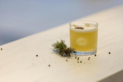 a glass of beer sitting on a table with dill at Hotel Indigo Cagnes-sur-Mer by IHG in Cagnes-sur-Mer