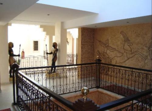 two people walking down a staircase in a building at Le Temple Des Arts in Ouarzazate