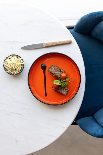 an orange plate of food on a white table at Hotel Indigo Cagnes-sur-Mer by IHG in Cagnes-sur-Mer