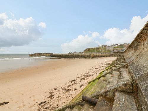 a view of a beach with a retaining wall at Dookers' Hoose in Buckie