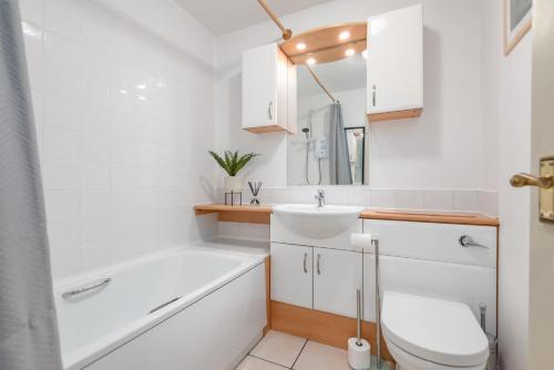 a bathroom with a tub and a sink and a toilet at Castle Loft - 2 Bed - Central - Close to castle in St. Andrews