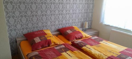 two beds with colorful pillows on them in a bedroom at Kockscher Hof in Mittweida