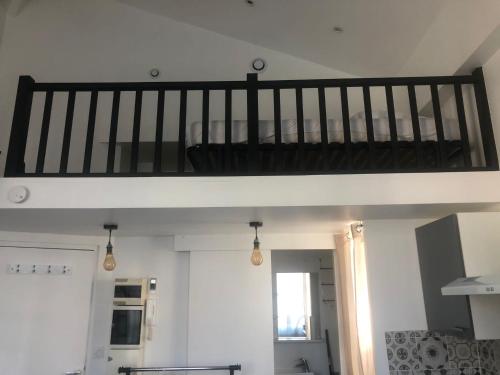 un lit en mezzanine dans un salon avec un escalier dans l'établissement Charmant studio proche mer, à Nice