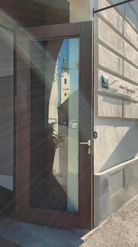 a door to a building with a reflection of a church at Vierzigerhof in Langenlois