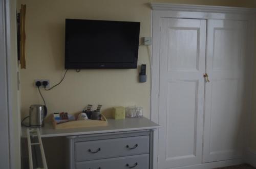 a flat screen tv on a wall above a dresser at Varley House in Ilfracombe