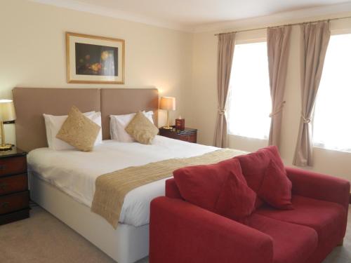 a bedroom with a bed and a red couch at Morangie Hotel Tain in Tain