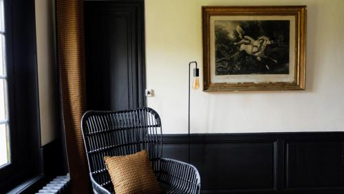 a black chair in a room with a painting on the wall at Château d'Aigneville in Aigneville