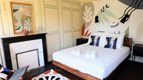 a bedroom with a bed and a fireplace at Château d'Aigneville in Aigneville