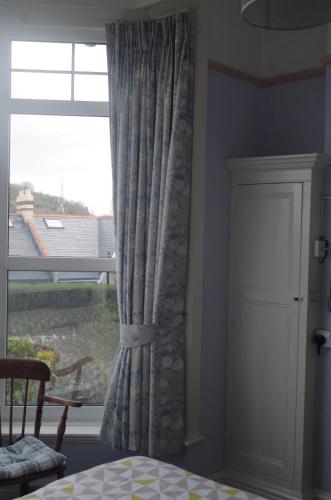 a window with a curtain in a room at Varley House in Ilfracombe