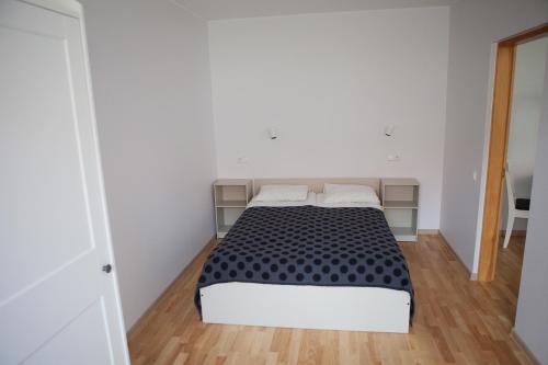 a bedroom with a bed in a white room at Prie Pušyno in Birštonas