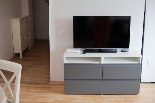 a white entertainment center with a tv on top of it at Prie Pušyno in Birštonas