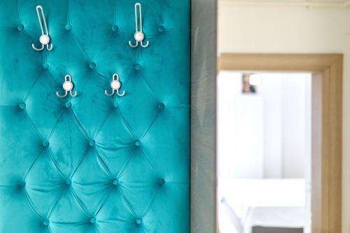 une pièce avec un mur bleu et des lumières dans l'établissement Turquoise Apartment Nord10 - Pool n Parking, à Mamaia