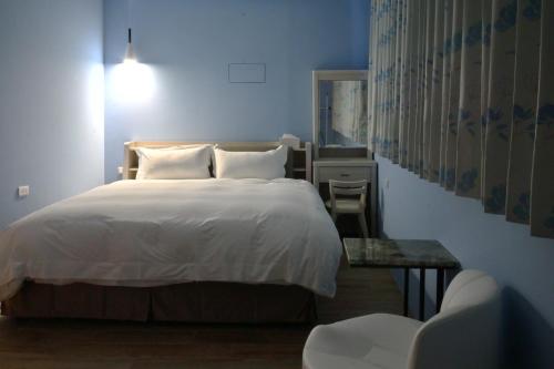 a bedroom with a white bed and a table at 小旅慢行 in Zhushan