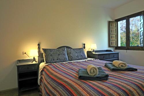 a bedroom with a bed with two towels on it at La Panadería at Molino la Ratonera in Granada