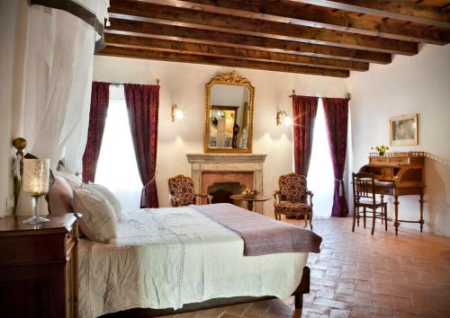 1 dormitorio con cama, escritorio y espejo en L'Unicorno Agriturismo, en bedizzol