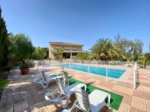 ein Haus mit einem Pool mit Chaiselongues in der Unterkunft Stunning 5 bed Villa La Font, private pool in El Campello