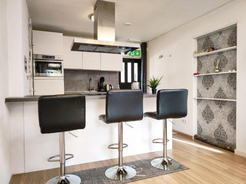 a kitchen with two bar stools in front of a counter at Studio with sauna in Amsterdam