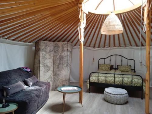 una sala de estar con cama y sofá en una yurta en Finca Las Hierbas B&B en Alora