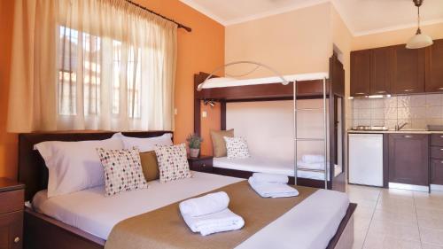 a bedroom with two bunk beds and a kitchen at House Chrysoula Mitsokopi in Sarti