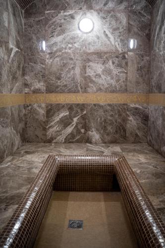 a bathroom with a stone wall and a brown escalator at Chagala Bautino Hotel in Bautino