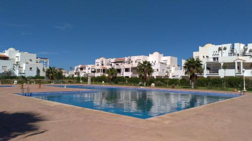 ein großer Pool vor einigen Gebäuden in der Unterkunft Chez Younès Appartement Marina Saidia Ap8 in Saidia 