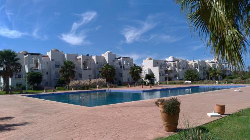 een zwembad voor sommige appartementsgebouwen bij Chez Younès Appartement Marina Saidia Ap8 in Saidia 
