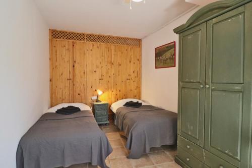 - une chambre avec 2 lits et une armoire verte dans l'établissement El Granero at Molino la Ratonera, à Zagra
