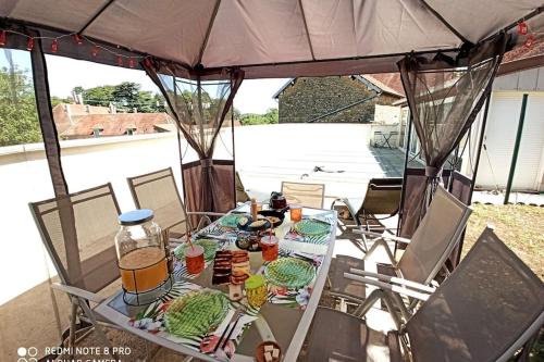 una mesa bajo una tienda con comida y bebidas. en JURA - Maison de village entière avec piscine en Rotalier
