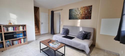 a living room with a couch and a coffee table at Gîtes De Saint Rémy in Villers-Cotterêts