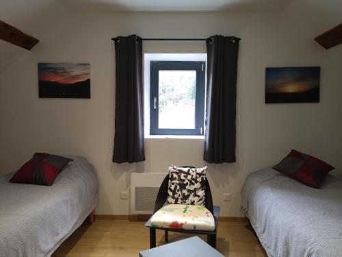 um quarto com duas camas e uma cadeira e uma janela em Le logis aux digitales em La Croix-aux-Mines