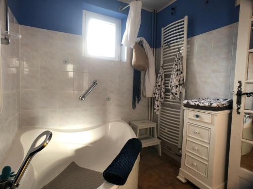 a bathroom with a bath tub and a window at Domaine de l'Angevinière, 2 gîtes cosy, vue bocage proche Mont St-Michel in Saint-Laurent-de-Terregatte