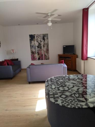 un salon avec un canapé et une table dans l'établissement Le logis aux digitales, à La Croix-aux-Mines