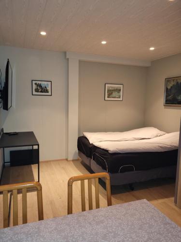 a bedroom with two beds and a table and chairs at Cozy studio apartment in central Akureyri. in Akureyri
