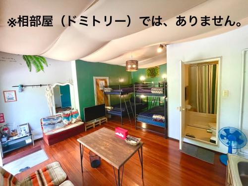uma sala de estar com uma mesa e um beliche em 秘密基地 NO's ARROW ノーズアロー em Onna