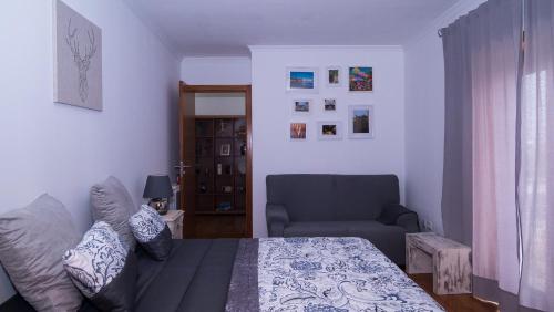 a bedroom with a bed and a couch and a chair at Casa Miguelito in Aveiro