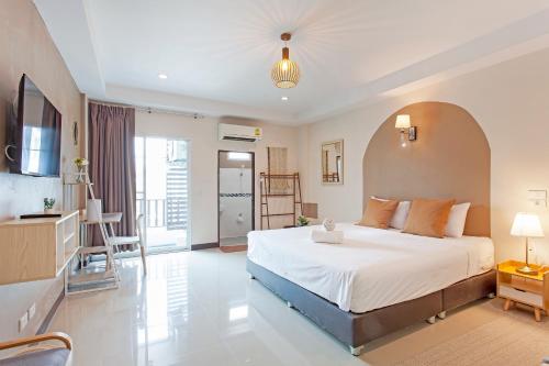 a bedroom with a large white bed in a room at Cozzi by Grand Airport Resort in Lat Krabang
