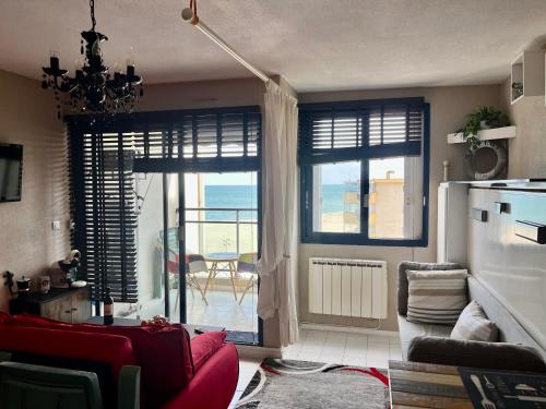 - un salon avec un canapé rouge et une vue sur l'océan dans l'établissement Studio avec vue sur la mer, à Canet