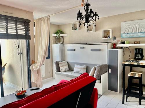 un salon avec un canapé rouge et une table dans l'établissement Studio avec vue sur la mer, à Canet