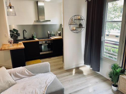 un salon avec un canapé et une cuisine dans l'établissement Appartement Centre Ville avec Garage, à Troyes
