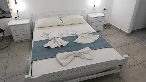 een bed met witte lakens en strikjes erop bij Apanemia 2 in Kinion