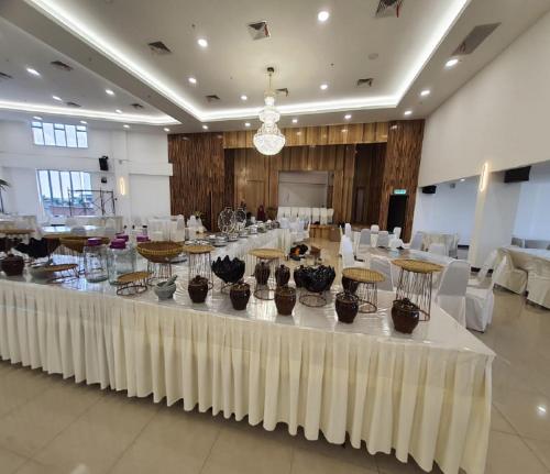 a large banquet hall with a large table with vases on it at Sri Indar Hotel & Suites in Parit Buntar