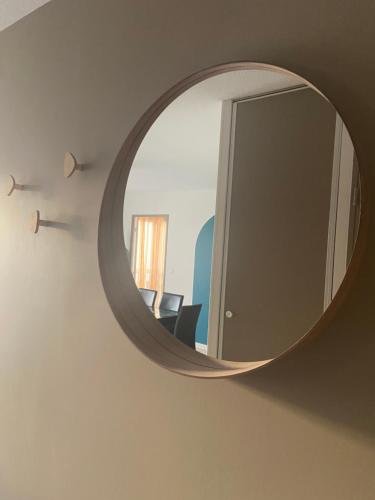 un miroir mural avec une chaise dans la chambre dans l'établissement Appartement de standing au port de l’Aiguillon, à Arcachon