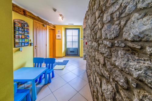 a room with a stone wall and blue tables and chairs at Gite d'Hamptay in Han-sur-Lesse