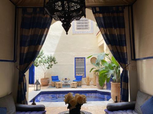 マラケシュにあるRiad Hotel Sherazadeのカーテン付きの客室からスイミングプールの景色を望めます。