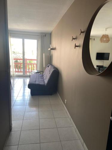 un salon avec un canapé et un miroir dans l'établissement Appartement de standing au port de l’Aiguillon, à Arcachon