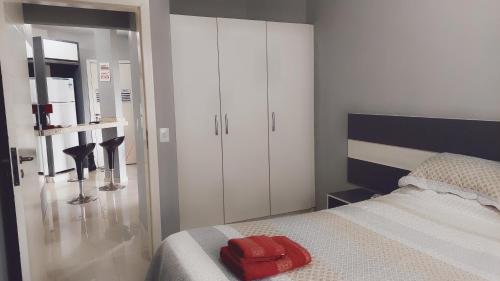 - une chambre avec un lit et une serviette rouge dans l'établissement Apart Hotel Guarapuvu, à Florianópolis