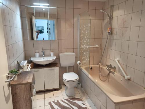 uma casa de banho com uma banheira, um WC e um lavatório. em Ferienwohnung Löwenzahn em Bad Harzburg