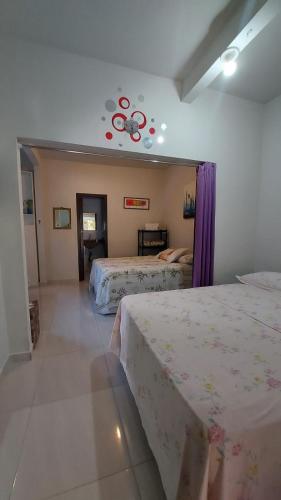 a bedroom with two beds with purple curtains at Pousada Executiva SolRiso Aeroporto Florianópolis in Florianópolis