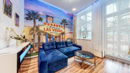 a living room with a blue couch and a sign at Apartament LAS VEGAS DE LUX-Deptak Dworcowa in Bytom